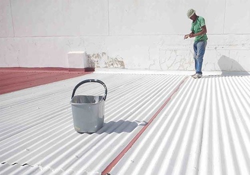 peinture cool roof sur le toit ondulé d'un entreprise